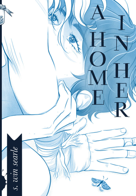 A Home in Her cover: All in blue tones, it's a  closeup of Aoi, a trans man, lying on the floor with a moth next to him.  He has freckles and dark hair, and his hand rests on the forearm of a  feminine person, Eerie, who's leaning over him with her hand braced on  the floor next to his head. She has a scrape on her elbow and bandages  on her hand, and her light-colored hair hangs over his face with her own  face cropped out of view. The man gazes up at her with sparkles in his  eyes, his nose and mouth cove